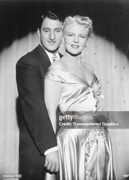 Portrait of American actors and singers Danny Thomas and Peggy Lee as they pose together in a spotlight, circa 1950. The print was issued by...