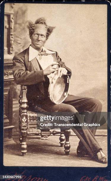 Carte-de-visite photo of American blackface minstrel Dan Bryant as he poses, seated and holding a tambourine, circa 1870. Bryant's stage...