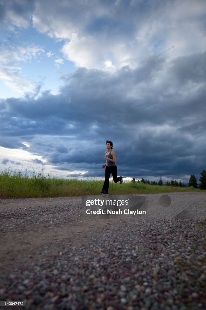 Mature woman running on country road