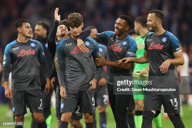 Alessandro Zanoli of SSC Napoli is embraced by teammates Matteo Politano, Juan Jesus and Amir Rrahmani at full-time after the UEFA Champions League...