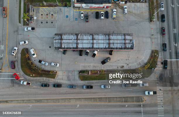 In this aerial view, people lineup as they wait for gas at a Circle K store after hurricane Ian passed through the area on October 4, 2022 in Cape...