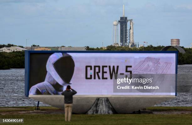 Person takes a photograph in the press area as SpaceX’s Falcon 9 rocket with the Dragon spacecraft atop is seen as Space X and NASA prepare for the...