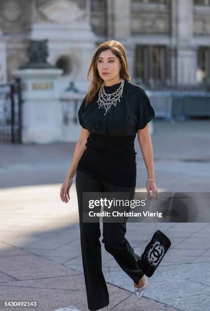 Paloma Cruz wears black top, pants, bag with logo, silver heels outside Chanel during Paris Fashion Week - Womenswear Spring/Summer 2023 : Day Nine...