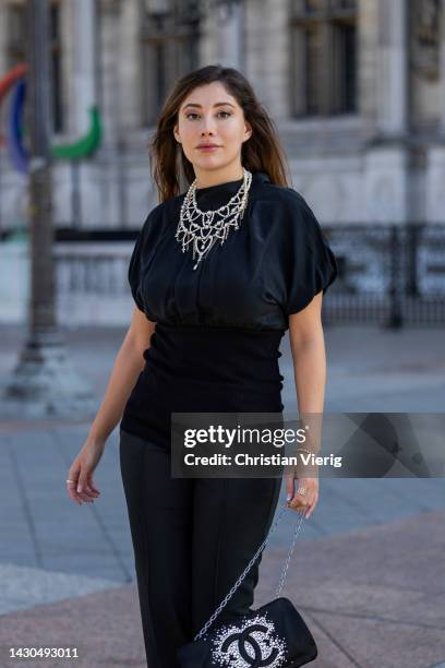 Paloma Cruz wears black top, pants, bag with logo, silver heels outside Chanel during Paris Fashion Week - Womenswear Spring/Summer 2023 : Day Nine...