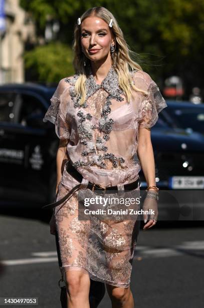 Leonie Hanne is seen wearing a pink sheer Miu Miu dress, brown belt, Miu Miu undergarments with white Miu Miu hair clips outside the Miu Miu show...