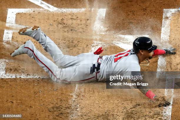 Orlando Arcia of the Atlanta Braves slides home against the Miami Marlins during the second inning of the game at loanDepot park on October 04, 2022...