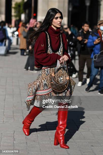 Guest is seen wearing a red Louis Vuitton sweater, knit dress, red boots and Louis Vuitton bag outside the Louis Vuitton show during Paris Fashion...