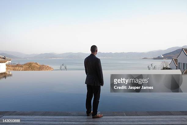 man looking out to lake in ningbo,china - vista posteriore foto e immagini stock