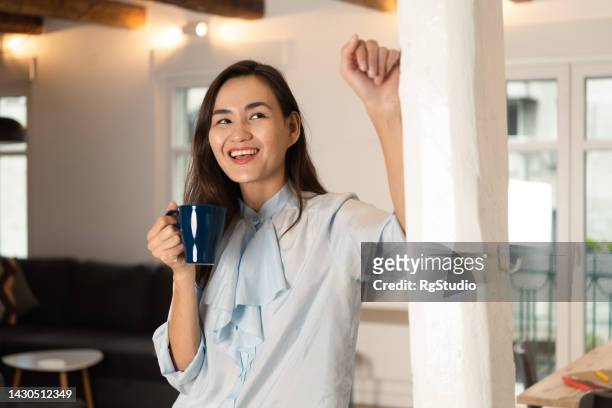 aufnahme einer mittelerwachsenen frau, die kaffee trinkt und zu hause entspannt - studio shot lonely woman stock-fotos und bilder