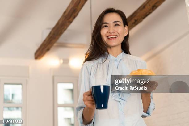 aufnahme einer mittelerwachsenen frau, die kaffee trinkt und zu hause entspannt - studio shot lonely woman stock-fotos und bilder