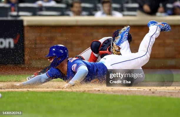 Pete Alonso of the New York Mets slides home safely as Tres Barrera of the Washington Nationals is unable to make the tag in the first inning during...