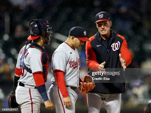 Pitching coach Jim Hickey of the Washington Nationals talks with starting pitcher Paolo Espino as catcher Tres Barrera looks on in the first inning...