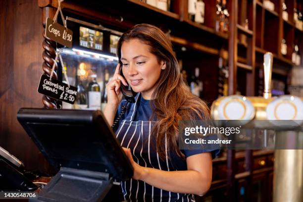 waitress working at a pub and talking on the phone - point of sale stock pictures, royalty-free photos & images