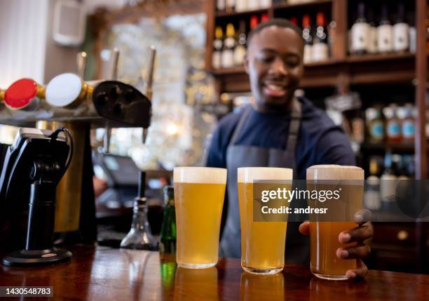 barman serving beer at the pub - craft beer festival stock pictures, royalty-free photos & images