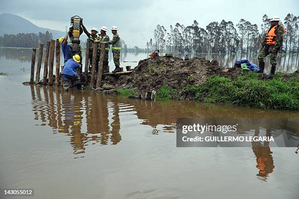 Soldiers repair a collapsed river dam following heavy rains and floods in the municipality of Cota, outskirts of Bogota, Colombia, on April 18, 2012....