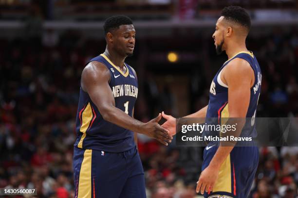 Zion Williamson of the New Orleans Pelicans high fives CJ McCollum against the Chicago Bulls during the second half of a preseason game at the United...