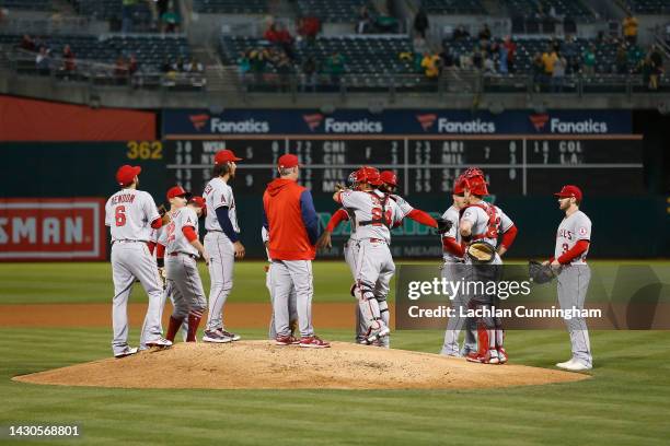 Catcher Kurt Suzuki of the Los Angeles Angels hugs teammates as he exits the game after the first pitch in the bottom of the first inning against the...