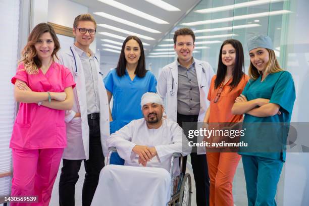 portrait of young medical professionals with patient at hospital - middelgrote groep mensen stockfoto's en -beelden