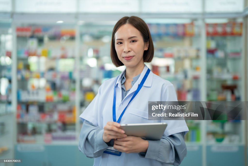 Retrato de uma farmacêutica asiática sorridente na farmácia