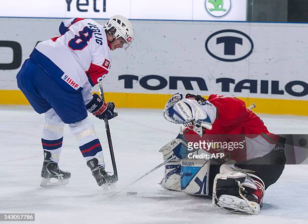 Slovenian Ziga Jeglic vies for the puck with Hungarian goalkeeper Bence Balizs during the 2012 IIHF Ice Hockey World Championship Div I Group A match...