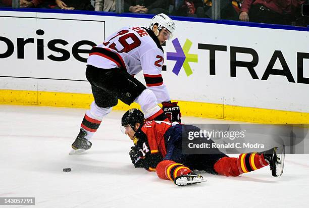 Tomas Fleischmann of the Florida Panthers hits the ice as Mark Fayne of the New Jersey Devils watches during Game Two of the Eastern Conference...