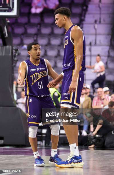 Tremont Waters and Victor Wembanyama of Boulogne-Levallois Metropolitans 92 talk as they walk onto the court after a timeout in the third quarter of...