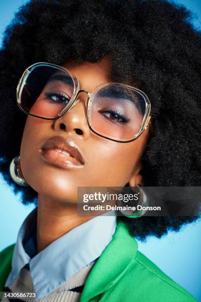 fashion, makeup and beauty with black woman and sunglasses against a blue background studio. cosmetics, afro hair style and creative portrait of young girl for luxury, lifestyle and designer clothing - creative makeup stockfoto's en -beelden