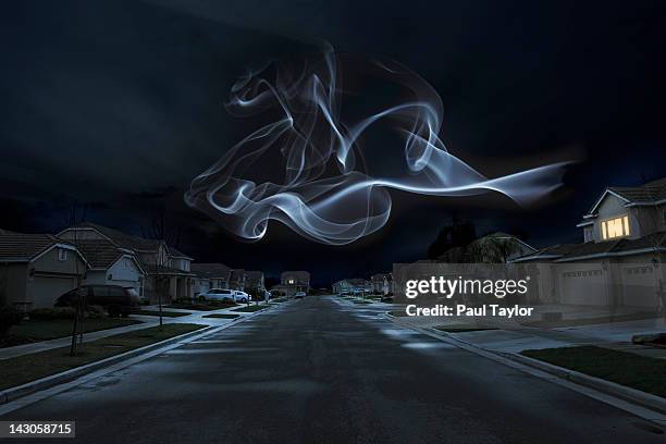 glowing shape over suburbs - creepy house at night stock-fotos und bilder