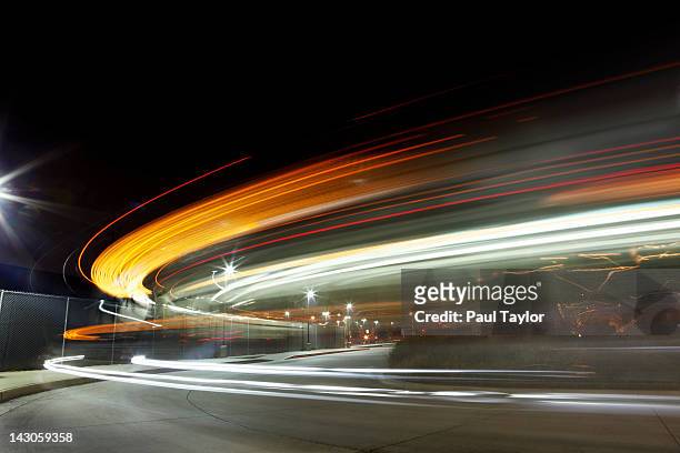 lights streaking in arc at night - street light stock pictures, royalty-free photos & images