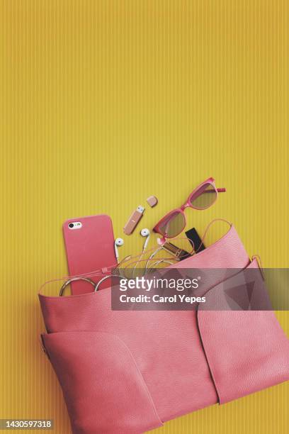 contents of woman bag in yellow background.top view - ハンドバッグ ストックフォトと画像