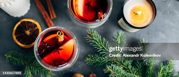 glasses of mulled wine with slice of orange, apple, anise and cinnamon stick with fir tree branch on background - anise stock-fotos und bilder