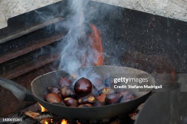 chestnut pan on hot fire in cooking - frying pan stock-fotos und bilder