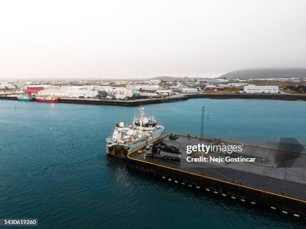 luftaufnahme eines großen fischerbootes, das mit einem kran entladen wird, grindavik island - iceland harbour stock-fotos und bilder