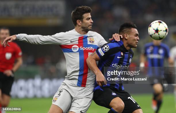 Lautaro Martinez of FC Internazionale battles for possession with Gerard Pique of FC Barcelona during the UEFA Champions League group C match between...