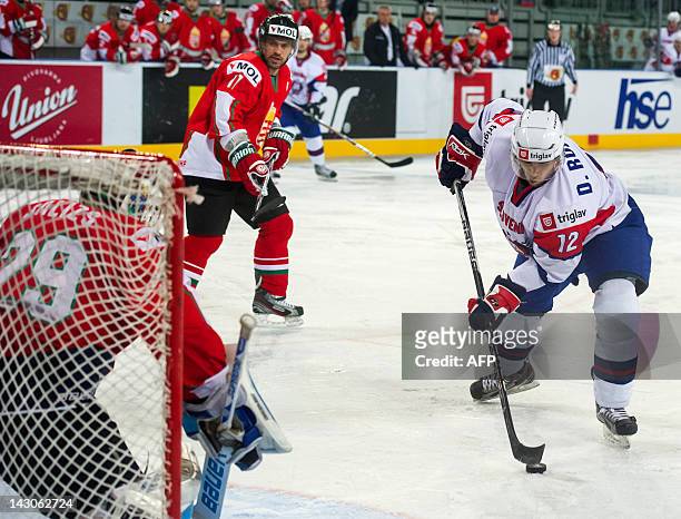 David Rodman of Slovenia vies for the puck with Hungarian goalkeeper Bence Balizs during the 2012 IIHF Ice Hockey World Championship Div I Group A...