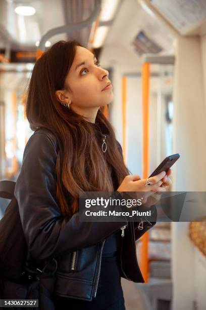 woman on metro train using smartphone - looking at subway map bildbanksfoton och bilder