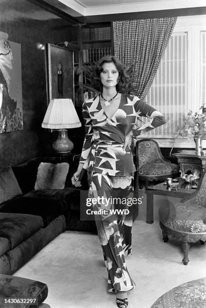 Model wears a Diane von Furstenberg seagull-printed wrap dress and poses in the designer's apartment. An Andy Warhol portrait of Diane von...