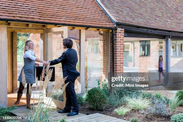 man and woman handing over briefcase at door of barn conversion house - barn conversion stockfoto's en -beelden