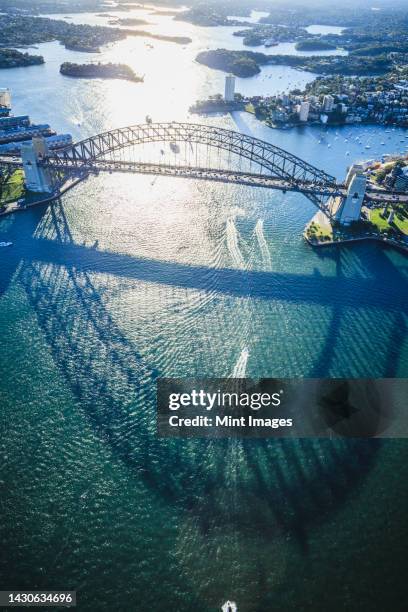 the sydney harbour bridge, the shadow of the arch on the water, and aerial view of the landscape - sydney cbd aerial view stock pictures, royalty-free photos & images