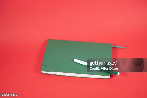 a pen on a student's notepad. red background. - skizzenblock stock-fotos und bilder