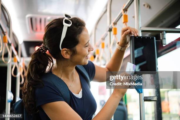 portrait of a happy young woman on vacation buying a ticket in the train - train ticket stock pictures, royalty-free photos & images