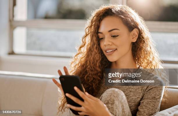 relax woman on sofa with smartphone, home wifi and internet for social media, networking online or chat on mobile app. gen z girl check or reading website information with smile on couch in a lounge - scrollen stockfoto's en -beelden