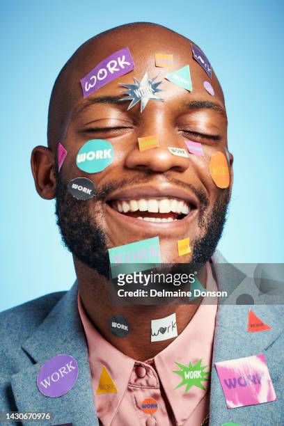 face, work and sticker with a business man in studio on a blue background with stickers on his head. happy, motivation and success with a black male employee with a smile and positive attitude - bem vestido imagens e fotografias de stock