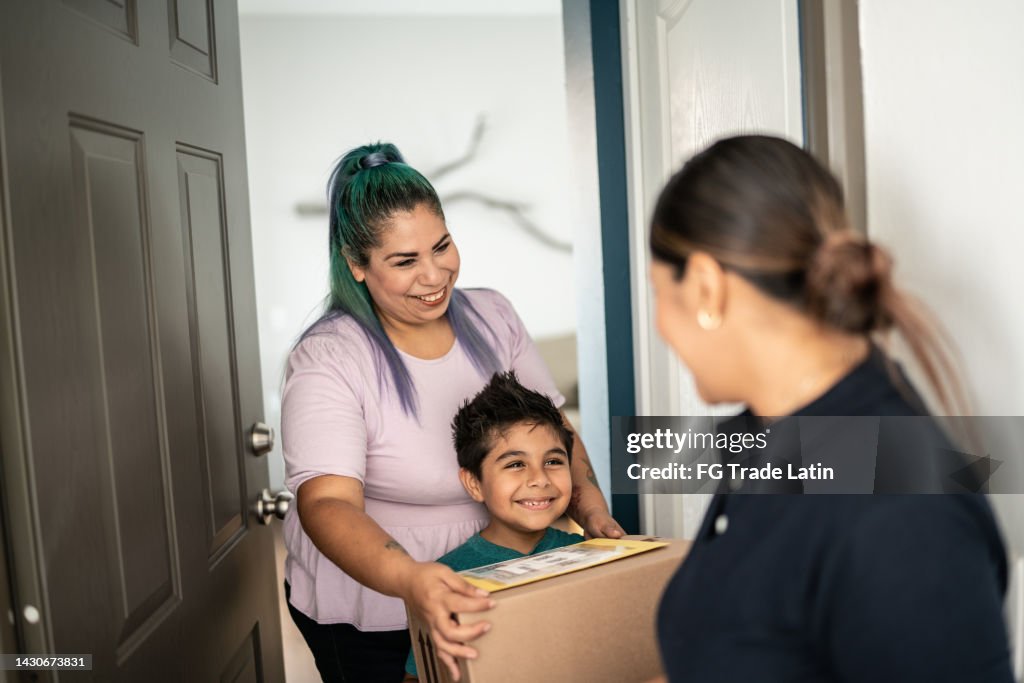 Mother and son receiving package at home entrance