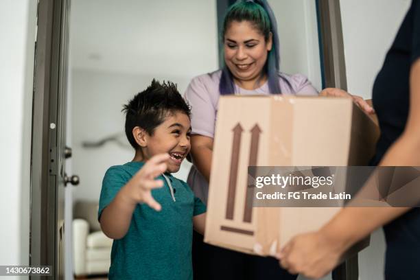 mother and son receiving package at home entrance - receiving delivery stock pictures, royalty-free photos & images