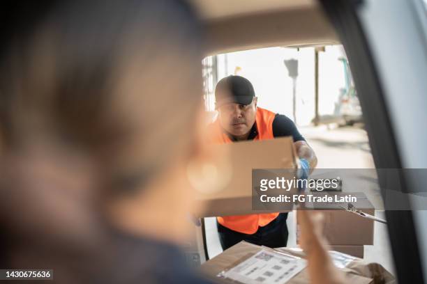 mid adult man ordering cardboard boxes on van truck - tradesman van stock pictures, royalty-free photos & images