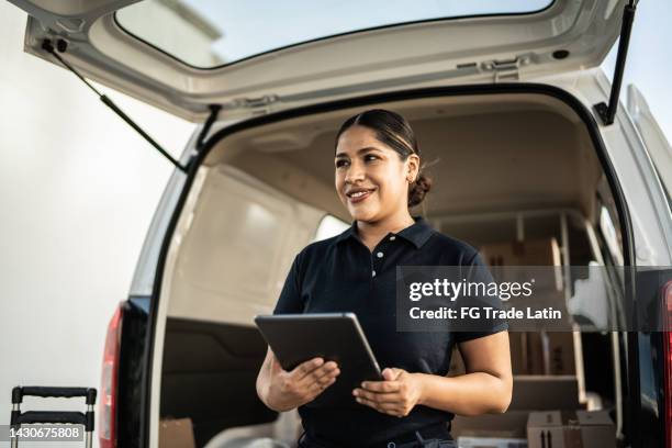 delivery person using digital tablet outdoors - delivery man stock pictures, royalty-free photos & images