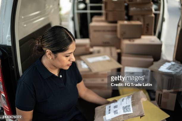 delivery woman ordering cardboard boxes on van truck - loader reading stock pictures, royalty-free photos & images