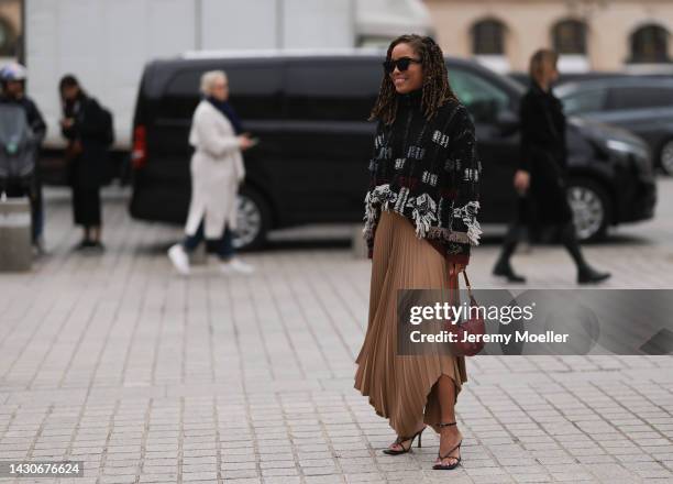 Guest is seen wearing black sunglasses, black/white wool knit fringed sweater, brown plated long skirt, red leather Ralph Lauren bag, black heels,...