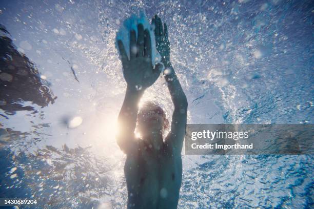 teenage boy swimming freestyle in pool - kid looking up to the sky imagens e fotografias de stock